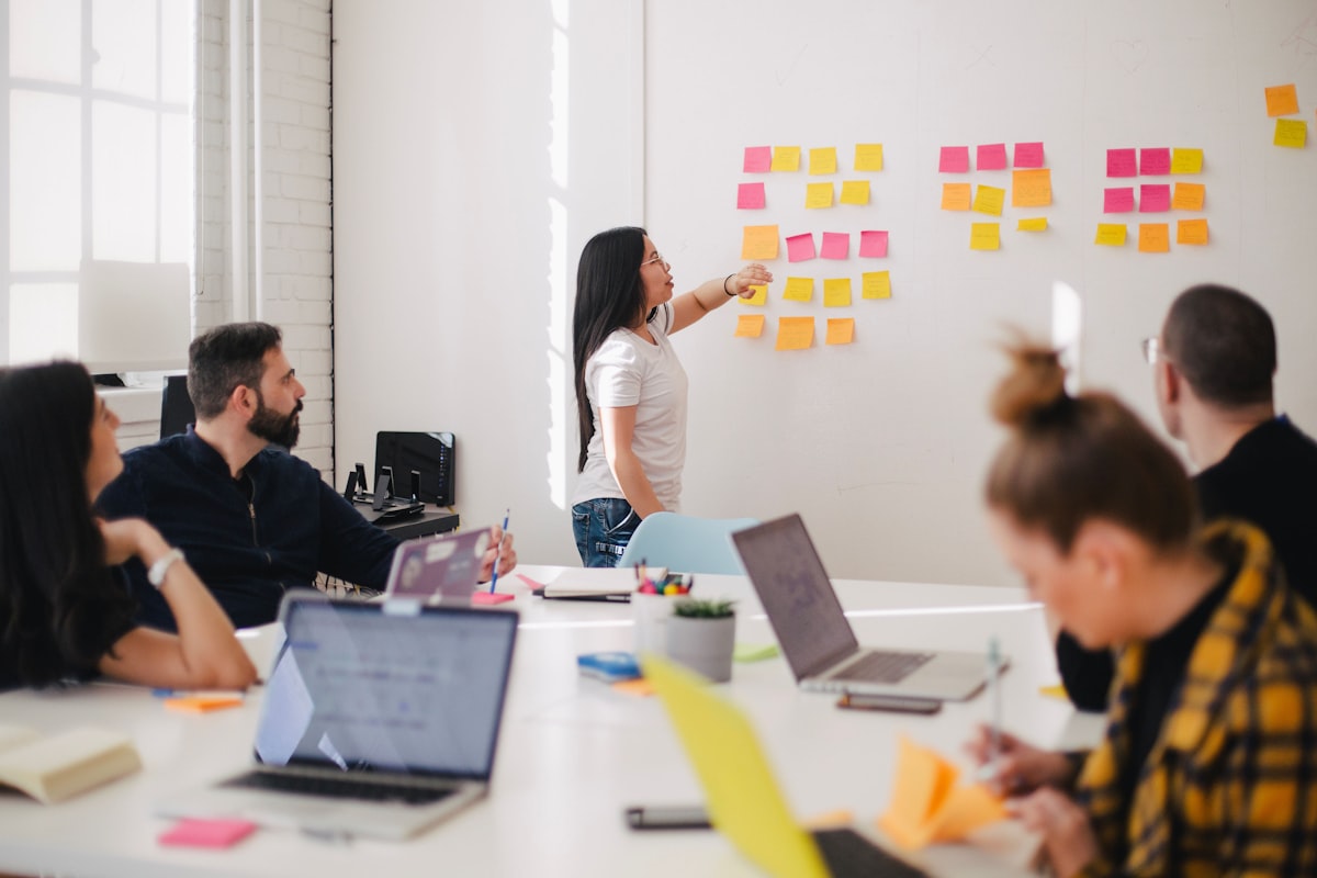 A team working through notes on a wall in a meeting room