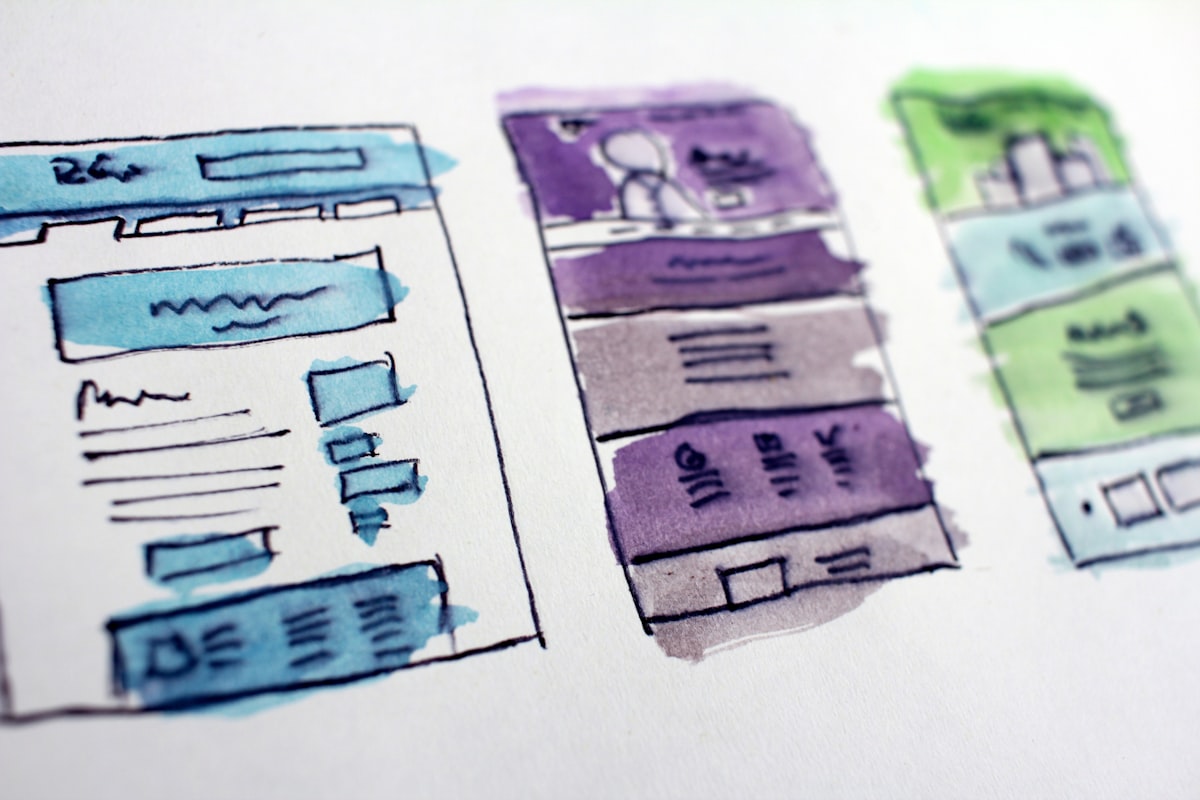 Hand-drawn interface wireframes in watercolour, laid out side by side on paper