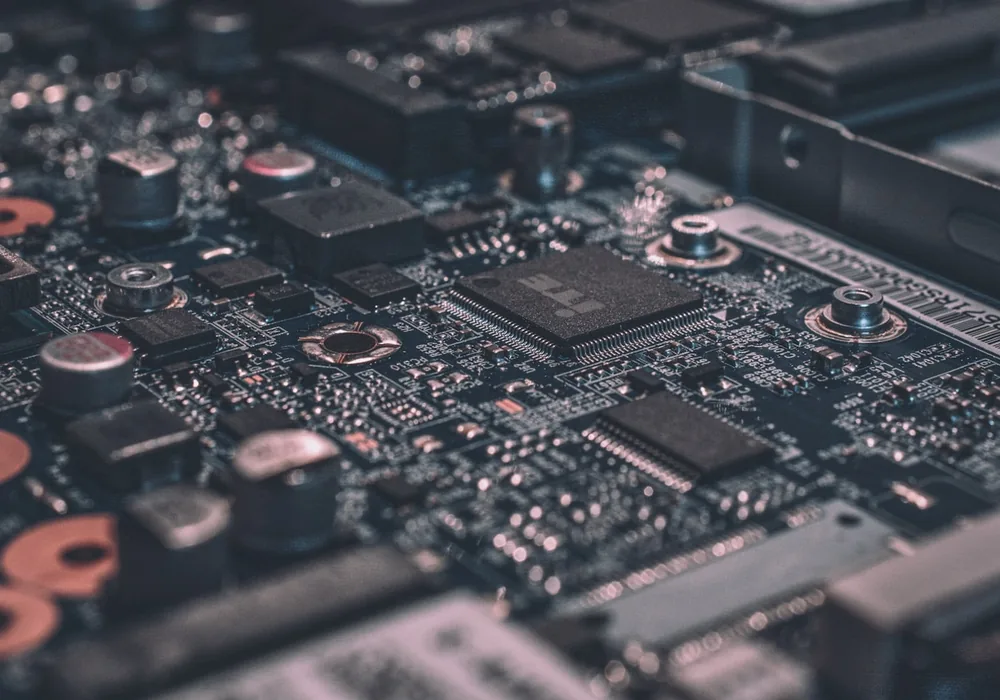 A close-up of an older circuit board, its components and traces in shallow focus