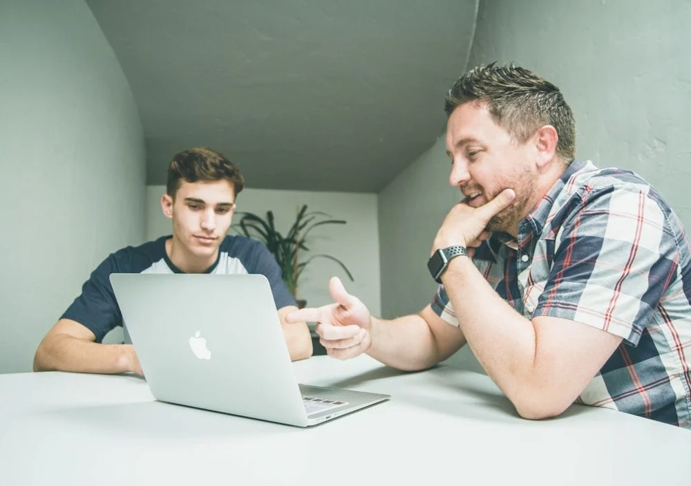 Two engineers reviewing work together at a laptop